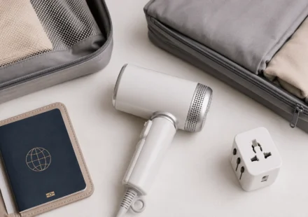 Folded travel hair dryer packed with passport and plug adapter for international travel