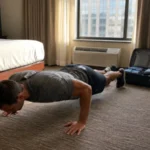 Traveler doing a bodyweight workout in a hotel room to stay fit while traveling Image Title: How to stay fit while traveling with a hotel room workout