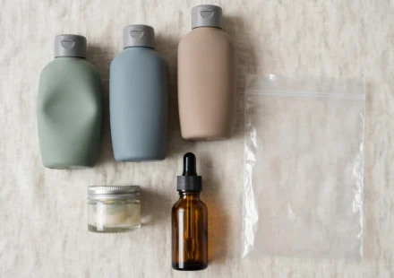 Travel toiletry bottles arranged for packing: silicone squeeze bottles, a screw-top jar, and a TSA quart bag.