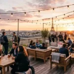 Travelers relaxing on a rooftop terrace at one of the best hostels in Paris with the Eiffel Tower visible