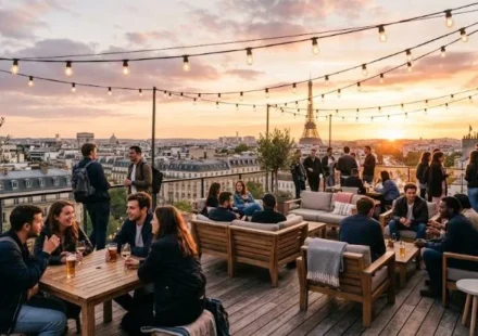 Travelers relaxing on a rooftop terrace at one of the best hostels in Paris with the Eiffel Tower visible