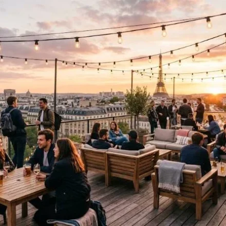 Travelers relaxing on a rooftop terrace at one of the best hostels in Paris with the Eiffel Tower visible