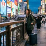 Traveler at the Dotonbori canal deciding where to stay in Osaka