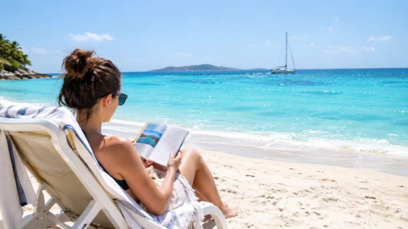 Turks and Caicos Travel Updates for 2026 3 Traveler reviewing Turks and Caicos travel updates while relaxing on Grace Bay beach
